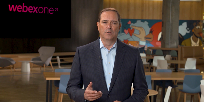 Chuck Robbins standing in collaboration space with WebexOne logo on screen behind him