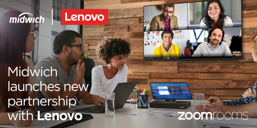 Diverse group of people sitting around a table in wood panelled room with Lenovo screen on the wall and another deivce on the table