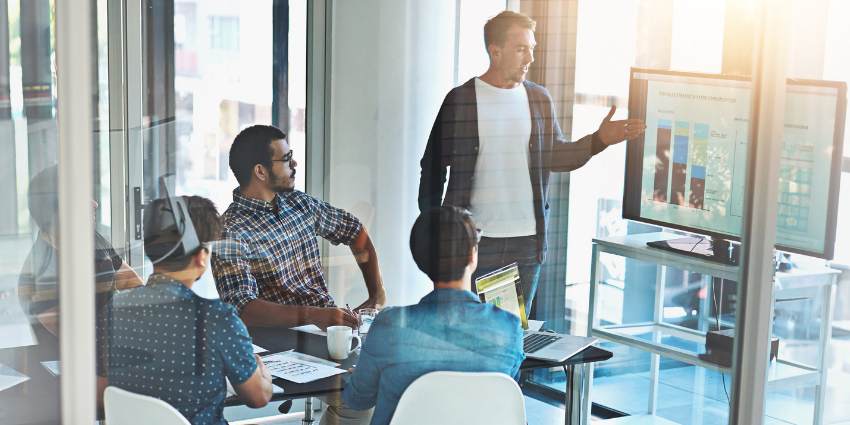 People sitting in an office watching a presentation with a large collaboration display